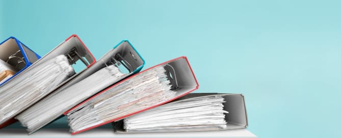 A stack of payroll binders has collapsed on its’ side.