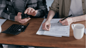 Two business owners work on their bookkeeping at a table.